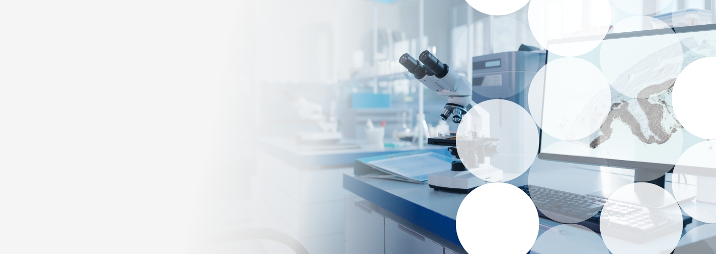 Laboratory setting with microscope and  computer monitor displaying a tissue sample — overlaid with an abstract white dot pattern